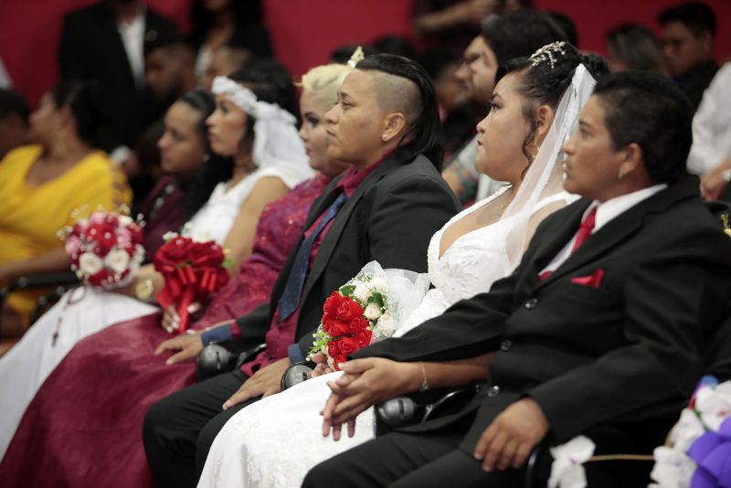 De vestido vermelho, a autónoma Kelly Ferrão, de 40 anos, segurando uma das mãos da noiva, a auxiliar de serviços gerais Suzana Pantoja, 35, não continha nos olhos a emoção pelo que estava por vir. "Chegamos aqui na luta, na raça mesmo. Estar aqui é um desafio vencido", confirmou, minutos antes de participar da 5a edição do Casamento Comunitário Homoafetivo, realizado na tarde desta sexta, 5, no auditório do Instituto de Ciências Jurídicas da Universidade Federal do Para (ICJ-UFPA). Além delas, outros dez casais de homens e mulheres gays, lésbicas, bissexuais e transexuais puderam oficializar, juridicamente, a relação estável, ou aos que queiram, apenas fazer a renovação dos votos. Embora não estivesse lotado, o espaço pareceu, diversas vezes, pequeno para comportar tanta emoção, orgulho e a certeza de que o amor sempre vence.
 <div class='credito_fotos'>Foto: Ricardo Amanajás / Ag. Pará   |   <a href='/midias/2019/originais/2851__j1o1081.jpg' download><i class='fa-solid fa-download'></i> Download</a></div>