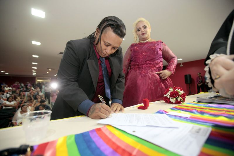 De vestido vermelho, a autónoma Kelly Ferrão, de 40 anos, segurando uma das mãos da noiva, a auxiliar de serviços gerais Suzana Pantoja, 35, não continha nos olhos a emoção pelo que estava por vir. "Chegamos aqui na luta, na raça mesmo. Estar aqui é um desafio vencido", confirmou, minutos antes de participar da 5a edição do Casamento Comunitário Homoafetivo, realizado na tarde desta sexta, 5, no auditório do Instituto de Ciências Jurídicas da Universidade Federal do Para (ICJ-UFPA). Além delas, outros dez casais de homens e mulheres gays, lésbicas, bissexuais e transexuais puderam oficializar, juridicamente, a relação estável, ou aos que queiram, apenas fazer a renovação dos votos. Embora não estivesse lotado, o espaço pareceu, diversas vezes, pequeno para comportar tanta emoção, orgulho e a certeza de que o amor sempre vence.
 <div class='credito_fotos'>Foto: Ricardo Amanajás / Ag. Pará   |   <a href='/midias/2019/originais/2851__j1o1183.jpg' download><i class='fa-solid fa-download'></i> Download</a></div>