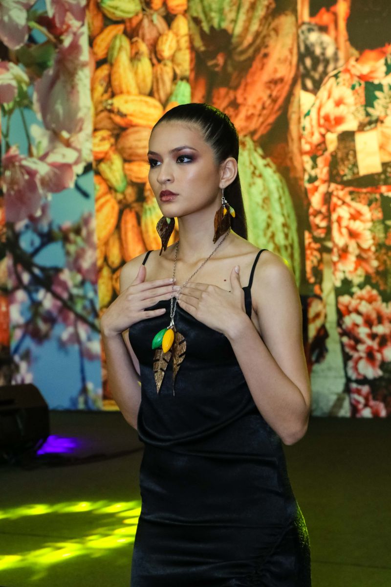 Um desfile de joias inspirado em flores e chocolate encerrou a programação do Chocolat Amazônia 2019 – 6º Festival Internacional do Chocolate e Cacau e da 18° Exposição Flor Pará, no terminou neste domingo (22), no Hangar Centro de Convenções, em Belém. A coleção “Encantos do Cacau e Chocolate” foi criada por 12 designs do programa Polo Joalheiro e do projeto Lua Nova. <div class='credito_fotos'>Foto: Jader Paes / Agência Pará   |   <a href='/midias/2019/originais/5488_desfiledejoiasnafeiradochocolatenohangar_017.jpg' download><i class='fa-solid fa-download'></i> Download</a></div>