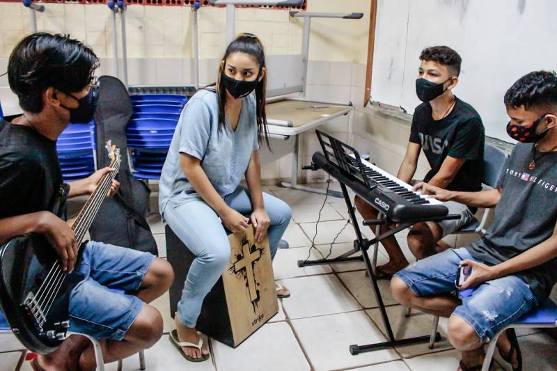 O estudante Eduardo Henrique Andrade (a esquerda) busca aprender mais sobre a música para tocar na igreja que frequenta