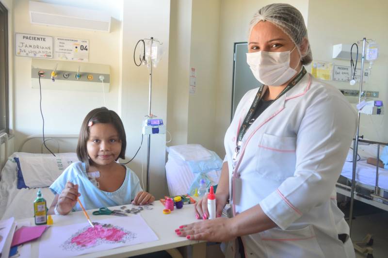 Paciente Jandriane Neres, de 6 anos, em atividade de pintura com a psicóloga Janaína Nascimento