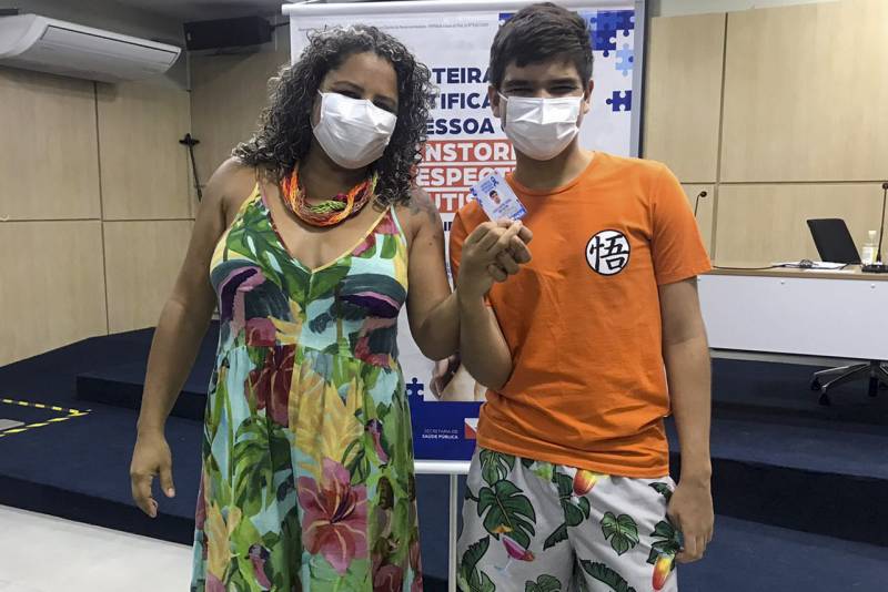 Mãe e filho felizes com o documento que garante atendimento prioritário em locais públicos e privados