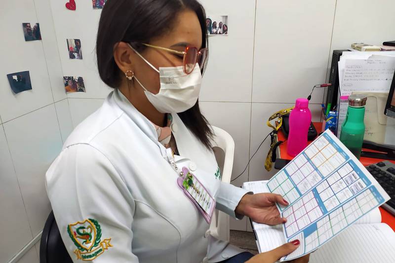 Enfermeira com a carteira de vacinação