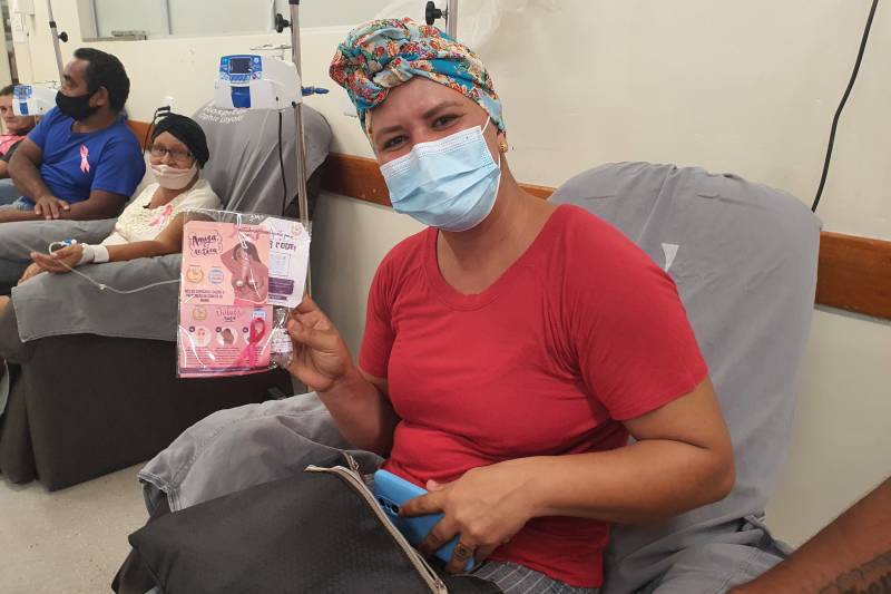  Vestindo o lenço que acabara de ganhar, paciente Suelem mostra um dos brindes que recebeu durante a ação.