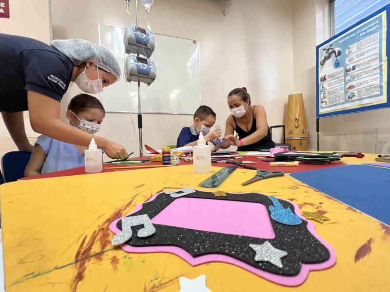 A colaboradora Bruna Dominguez orienta paciente durante artesanato. 