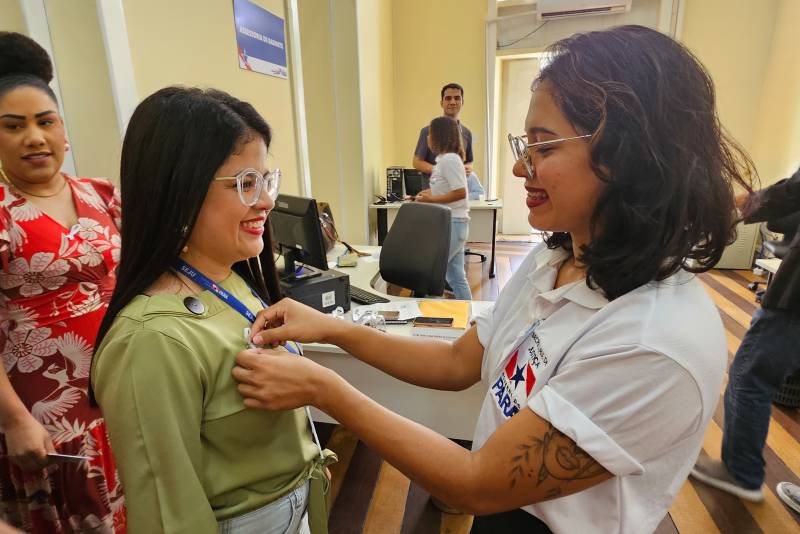 Servidores recebem o broche do laço branco, representando o tema da campanha