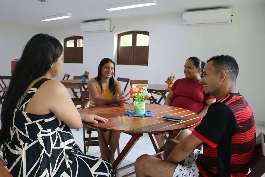 Acompanhante e pacientes conversam na sala de jantar da Casa