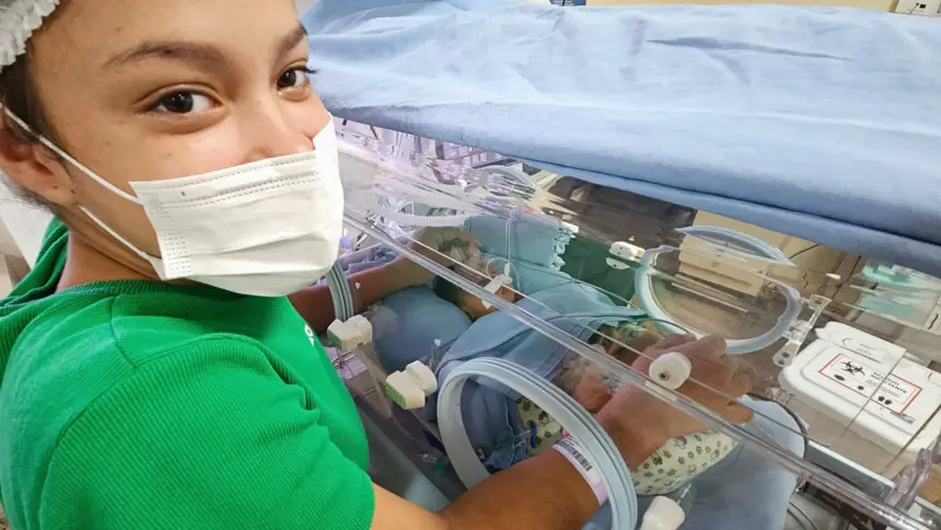 Mãe cuida do filho na incubadora, confiando na equipe de profissionais que também são mães